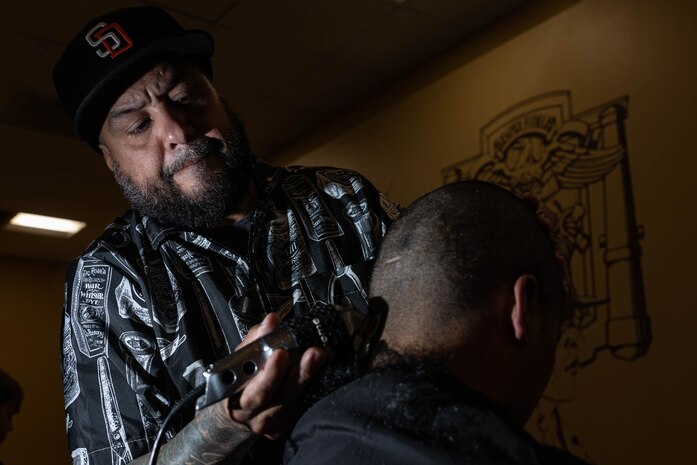 Mr. Felipe Garza, a barber for Marine Corps Recruit Depot San Diego, gives a recruit his initial haircut as a part of the receiving process at MCRD San Diego, California, May 13, 2024. During the receiving process, recruits are searched for contraband, given a haircut, allowed a phone call home, and issued gear. (U.S. Marine Corps photo by Lance Cpl. Sarah M. Grawcock)