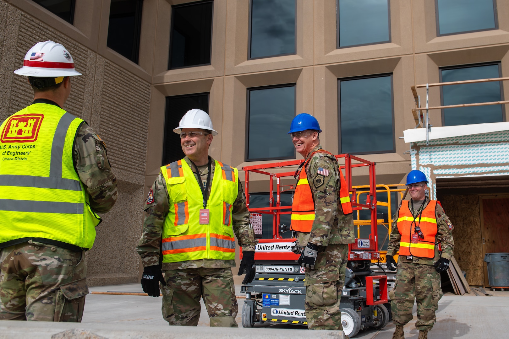 Men in military uniforms wearing construction gear and hard hats