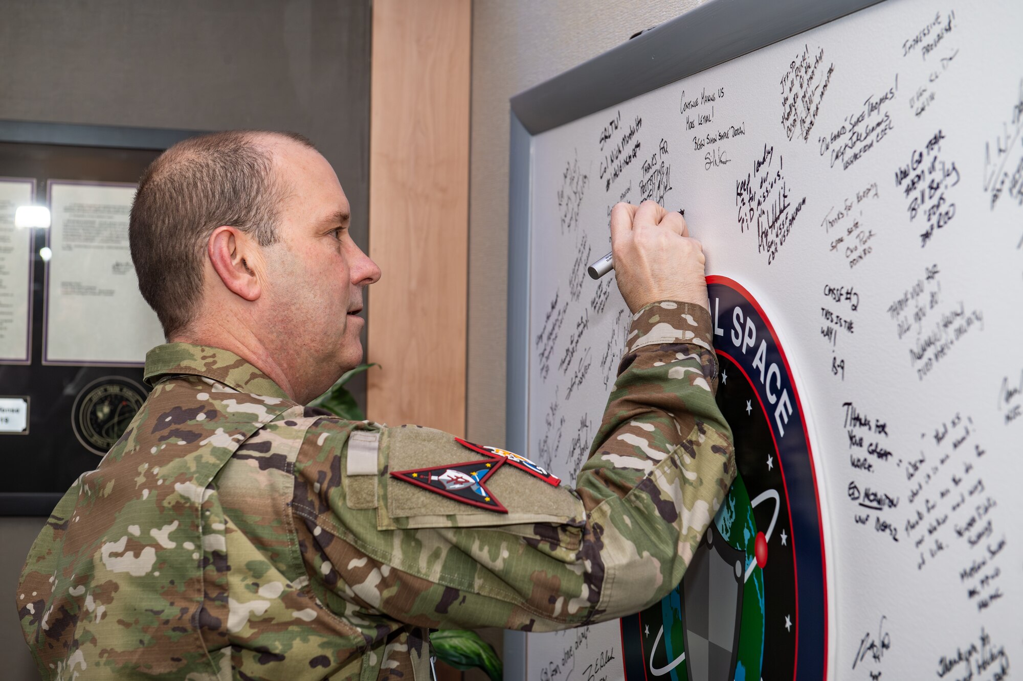 Man in uniform signing board