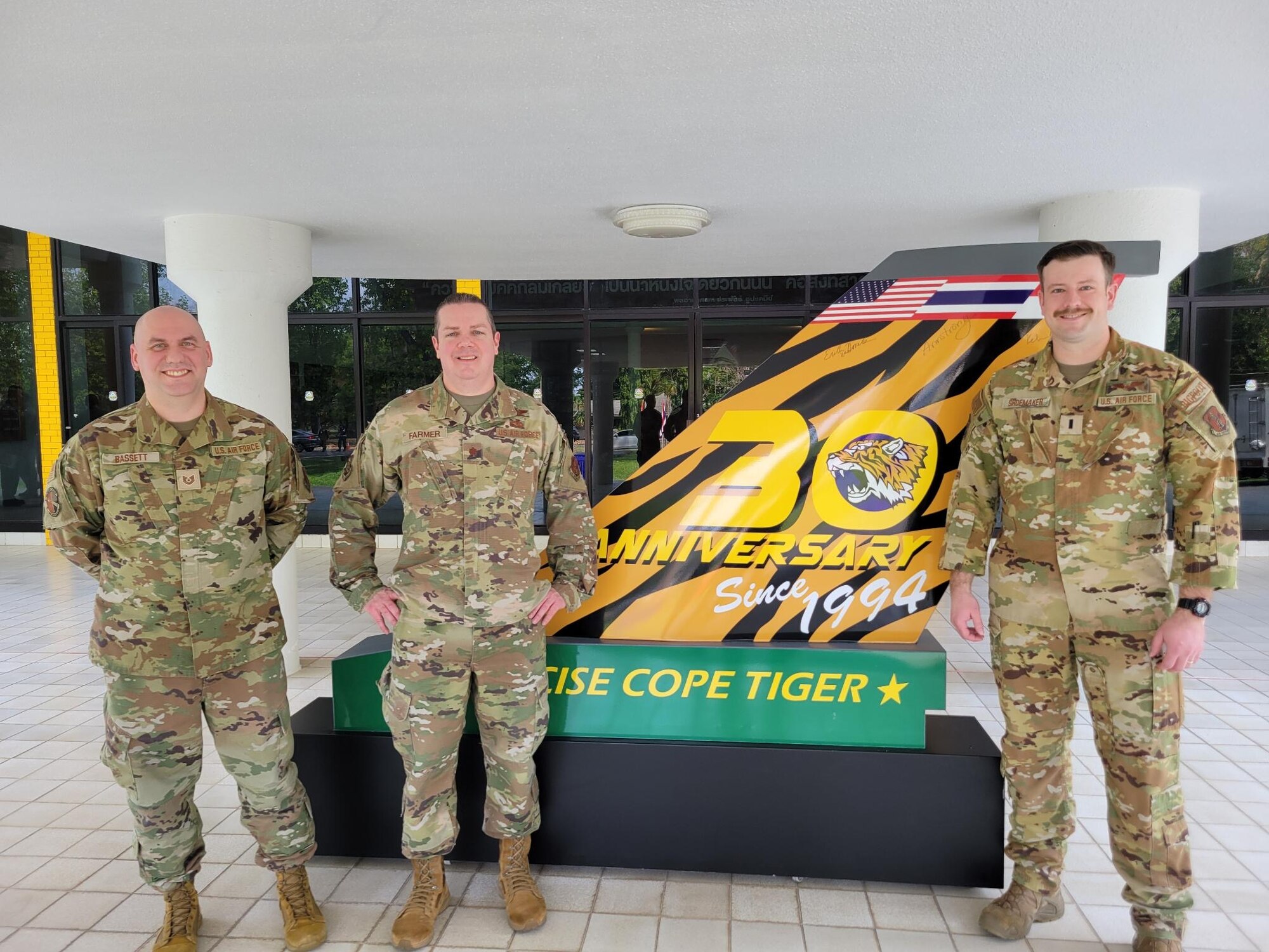 Airmen standing in front of sign