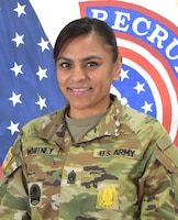 Female Soldier posed in front of the U.S. flag and the USAREC flag.