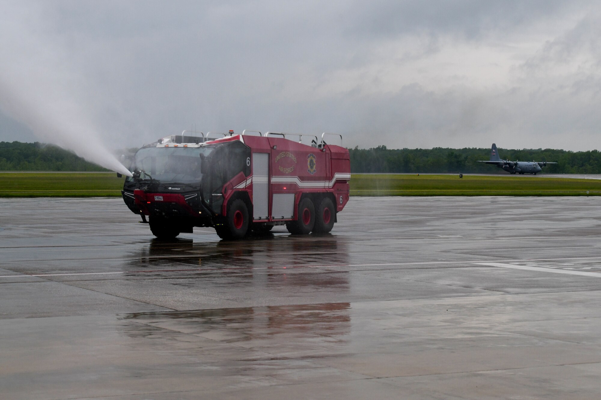 Fire engine 6 drives across the flightline as a C-130H Hercules assigned to Youngstown Air Reserve Station taxis after a flight, here, May 17, 2024, during an installation tour for local high school students.
