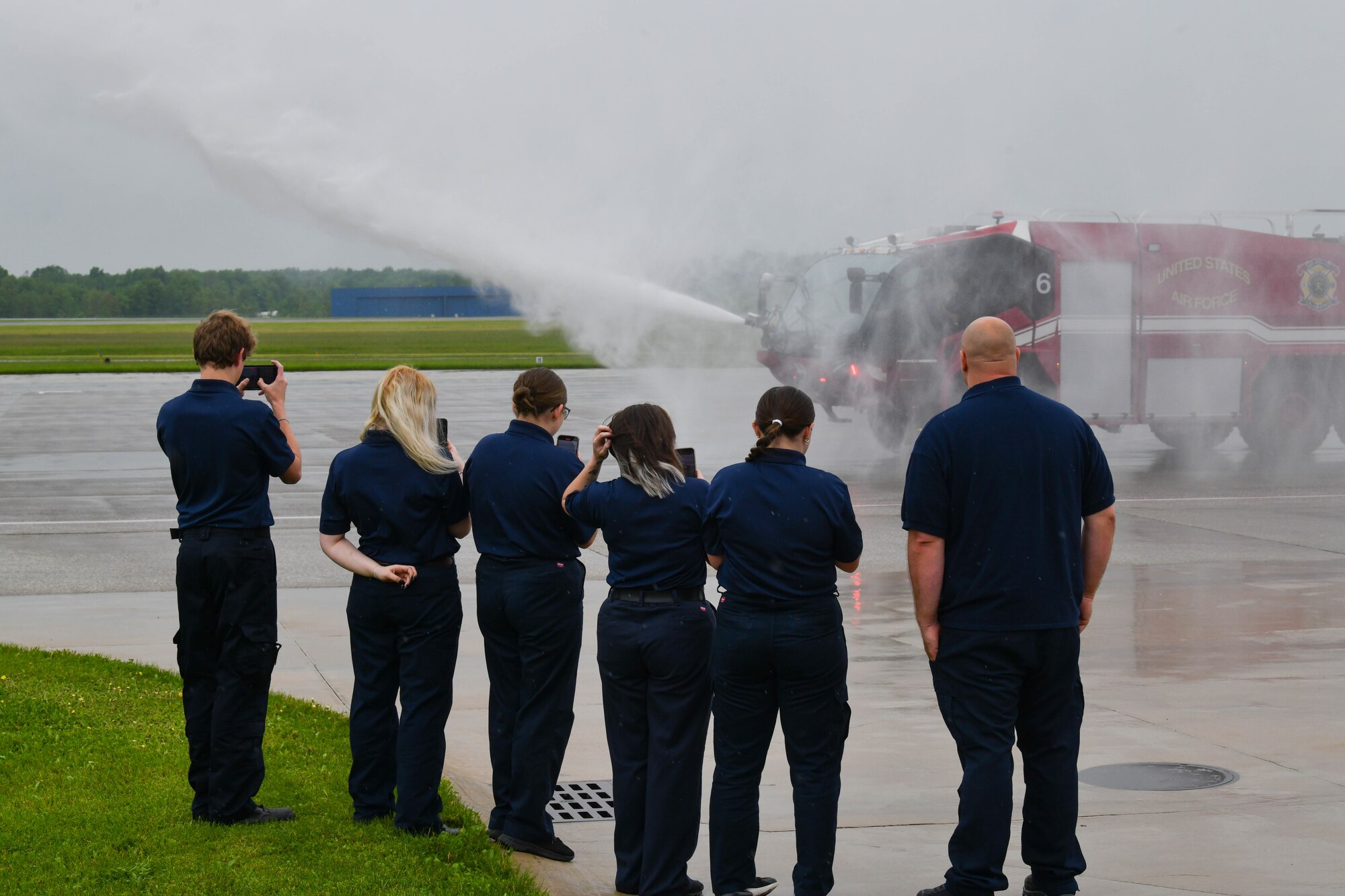 Students from Barberton High School and Thomas Chadima, a firefighter assigned to the 910th Airlift Wing, watch as fire engine 6 sprays water during an installation tour at Youngstown Air Reserve Station, Ohio, May 17, 2024.