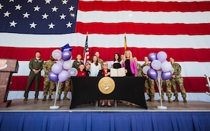 Arizona Governor Katie Hobbs and Luke Air Force Base members pose for a group photo with Arizona House Bill 2246 at a ceremonial signing.