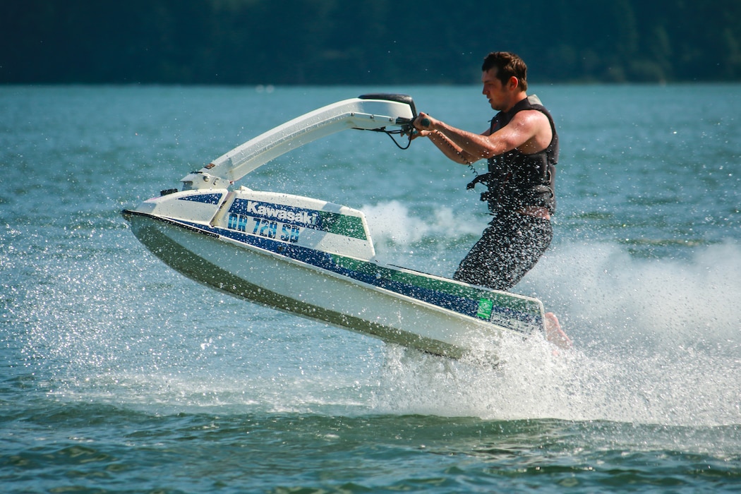 Man rides jetski on a body of water.