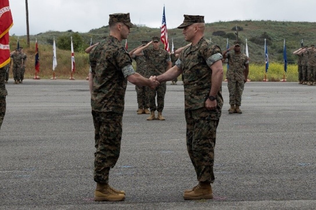 U.S. Marine Corps Lt. Col. Robert D. Reagles, left, incoming commanding officer of 1st Intelligence Battalion, I Marine Expeditionary Force Information Group, shakes hands with Lt. Col. Jason P. Pellerin, the outgoing commanding officer of 1st Intelligence Battalion, during the 1st Intelligence Battalion change of command ceremony at Marine Corps Base Camp Pendleton, California, May 17, 2024. The change of command ceremony commemorated the passing of command from Pellerin to Reagles. (U.S. Marine Corps photo by Lance Cpl. Nicole Stuart)