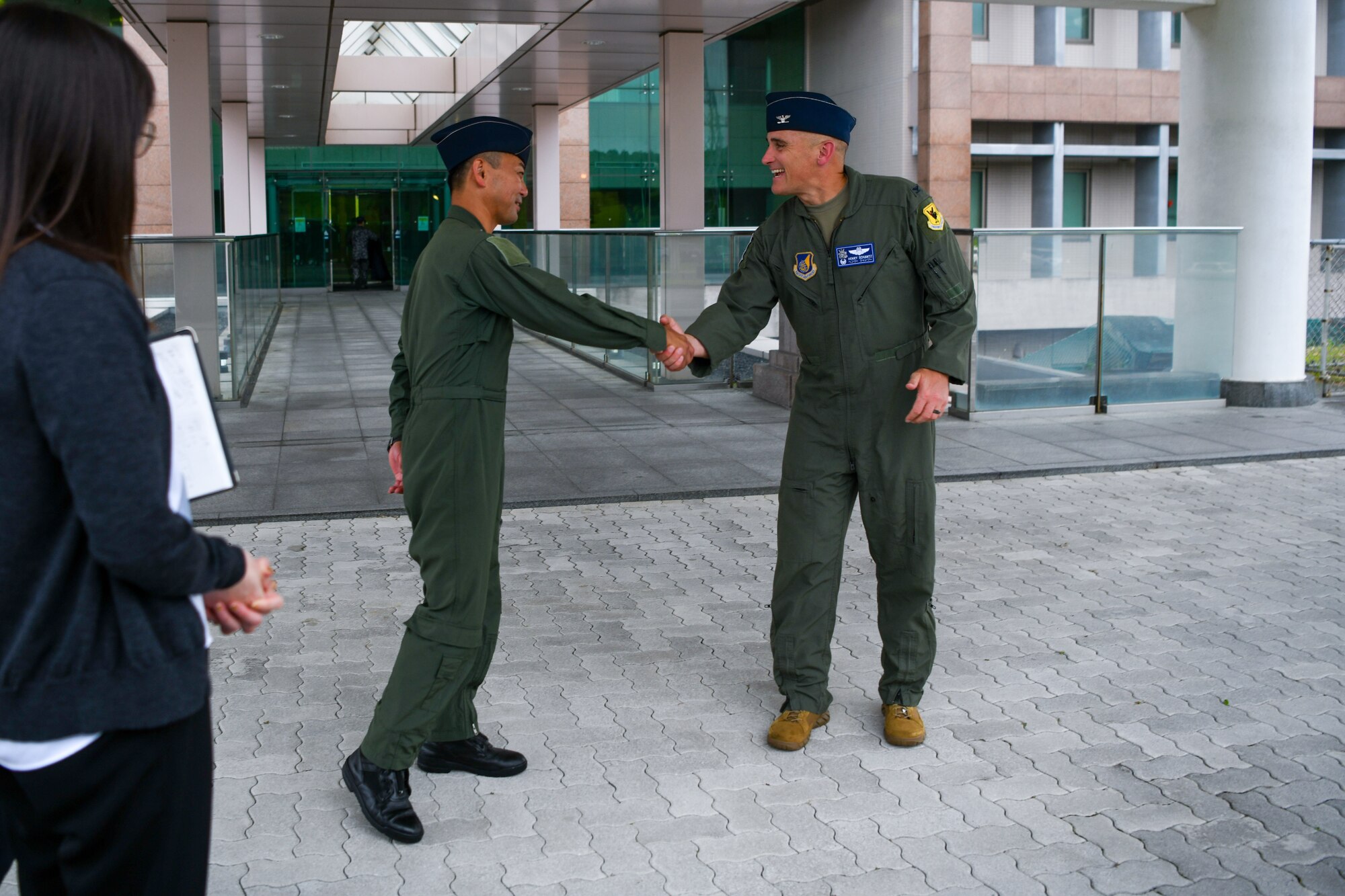 The 18th Operations Group commander and the Southwestern Air Defense Force defense plans and operations commander shake hands.