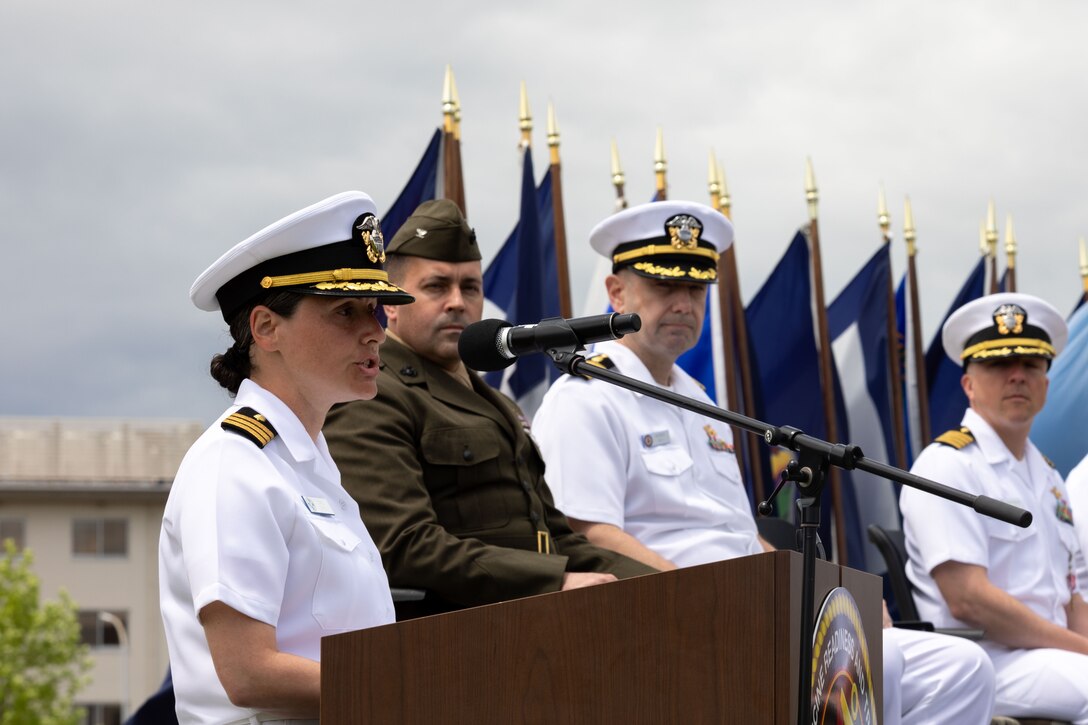 U.S. Navy Cmdr. Jacqueline Lopez, left, the incoming officer-in-charge of U.S. Navy Medicine Readiness and Training Unit Iwakuni, and a North Carolina native, gives a speech during a change of charge ceremony for U.S. Navy Medicine Readiness and Training Unit Iwakuni at Marine Corps Air Station Iwakuni, Japan, May 8, 2024. Naval Family Branch Clinic Iwakuni has the critical role of providing MCAS Iwakuni personnel and their families with healthcare services as well as helping to ensure medical readiness throughout the Indo-Pacific. The change of charge ceremony is a long-standing Naval tradition showcasing the absolute transfer of authority from one commander to another. (U.S. Marine Corps photo by Lance Cpl. Colin Thibault)