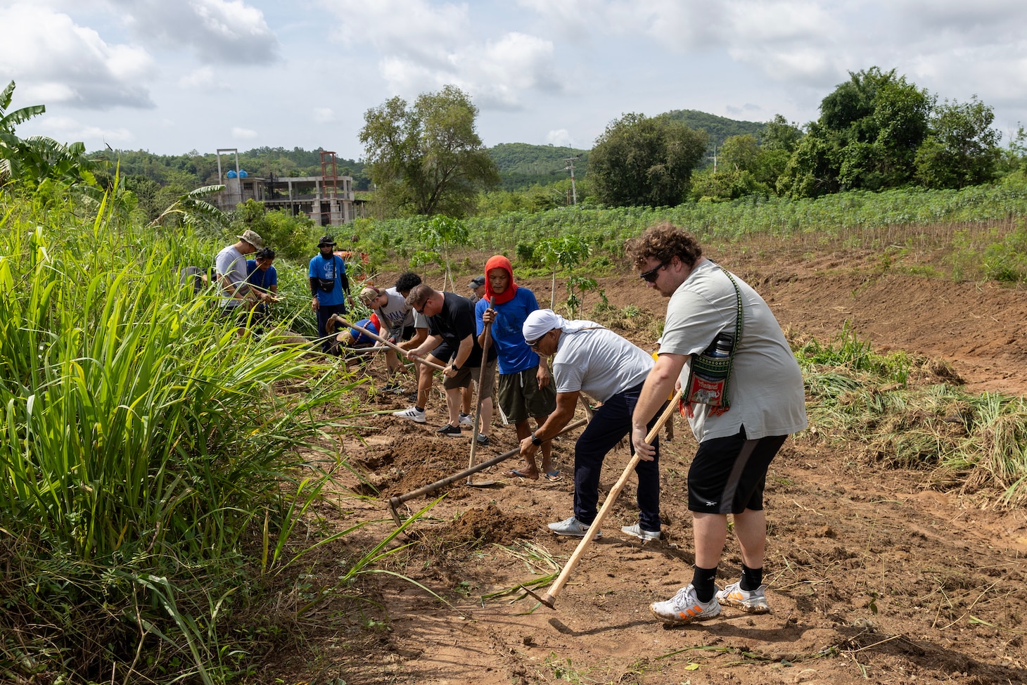 Eryk Michalowski, right, 3rd mate, along with the rest of his team from fleet replenishment oiler USNS Yukon (T-AO 202), prepare the field for planting vegetation, which will be food for elephants, at the Pattaya Elephant Sanctuary, in Sattahip, Thailand, during a community outreach event, May 17, 2024. (U.S. Navy photo by Grady T. Fontana)