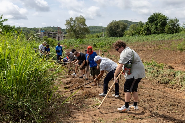 Eryk Michalowski, right, 3rd mate, along with the rest of his team from fleet replenishment oiler USNS Yukon (T-AO 202), prepare the field for planting vegetation, which will be food for elephants, at the Pattaya Elephant Sanctuary, in Sattahip, Thailand, during a community outreach event, May 17, 2024. (U.S. Navy photo by Grady T. Fontana)