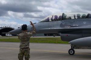 U.S. Air Force Airman 1st Class Jayrekallen Pace, 13th Fighter Generation Squadron, crew chief, marshals Col. Michael Richard, 35th Fighter Wing commander, and Mr. Yoshinori Kohiyama, Misawa City mayor, in an F-16 Fighting Falcon before a high-speed taxi at Misawa Air Base, Japan, May 17, 2024. The coordination and teamwork between Pace and the pilot ensured a smooth and safe operation. This demonstration was part of the 'Wing Commander for a Day' program, which aims to strengthen ties with local community leaders and provide them with an immersive experience of the 35th Fighter Wing’s mission and operational capabilities (U.S. Air Force photo by Staff Sgt. Kristen Heller)