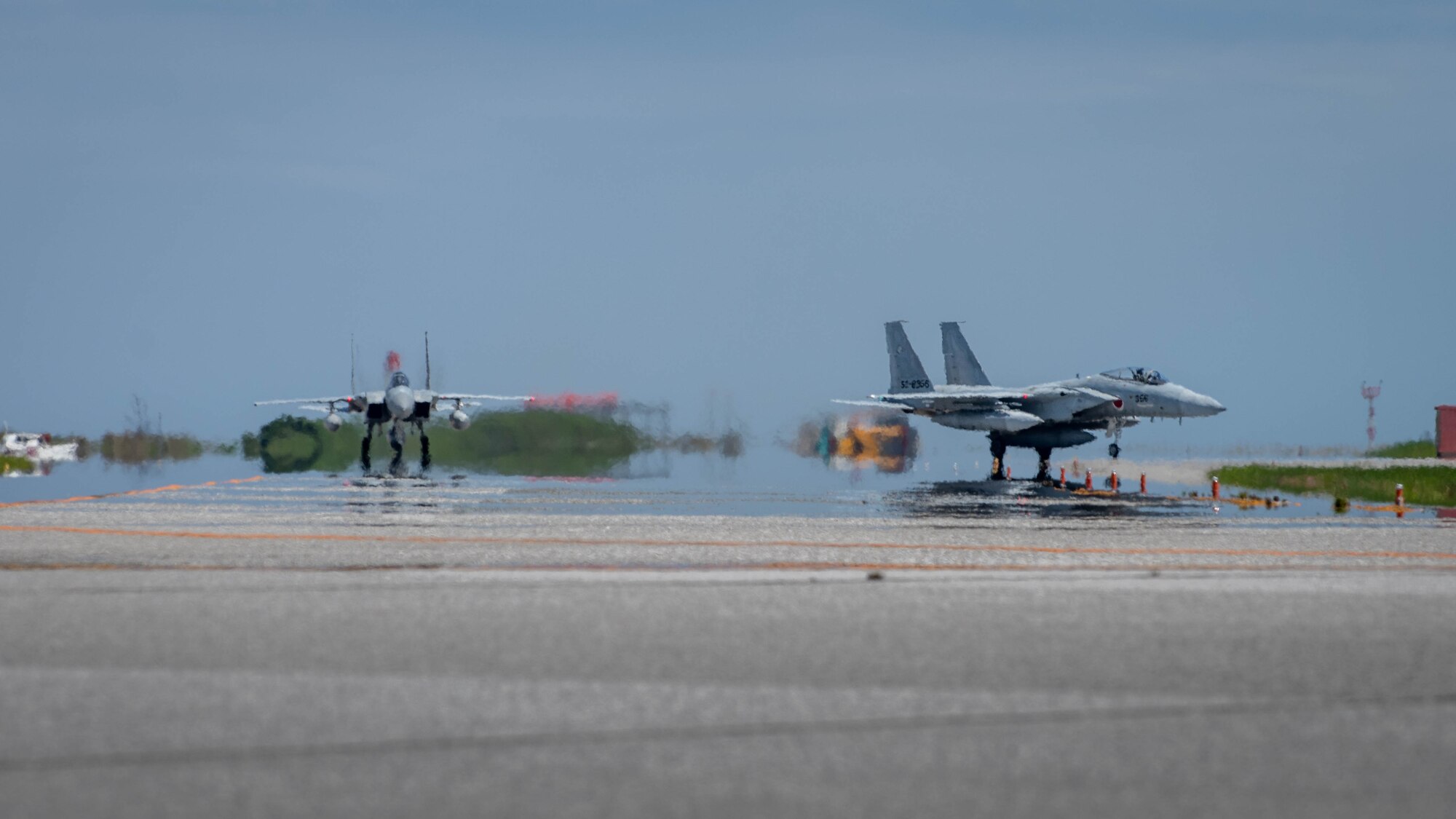 JASDF F-15J Eagles taxi on a flight line.