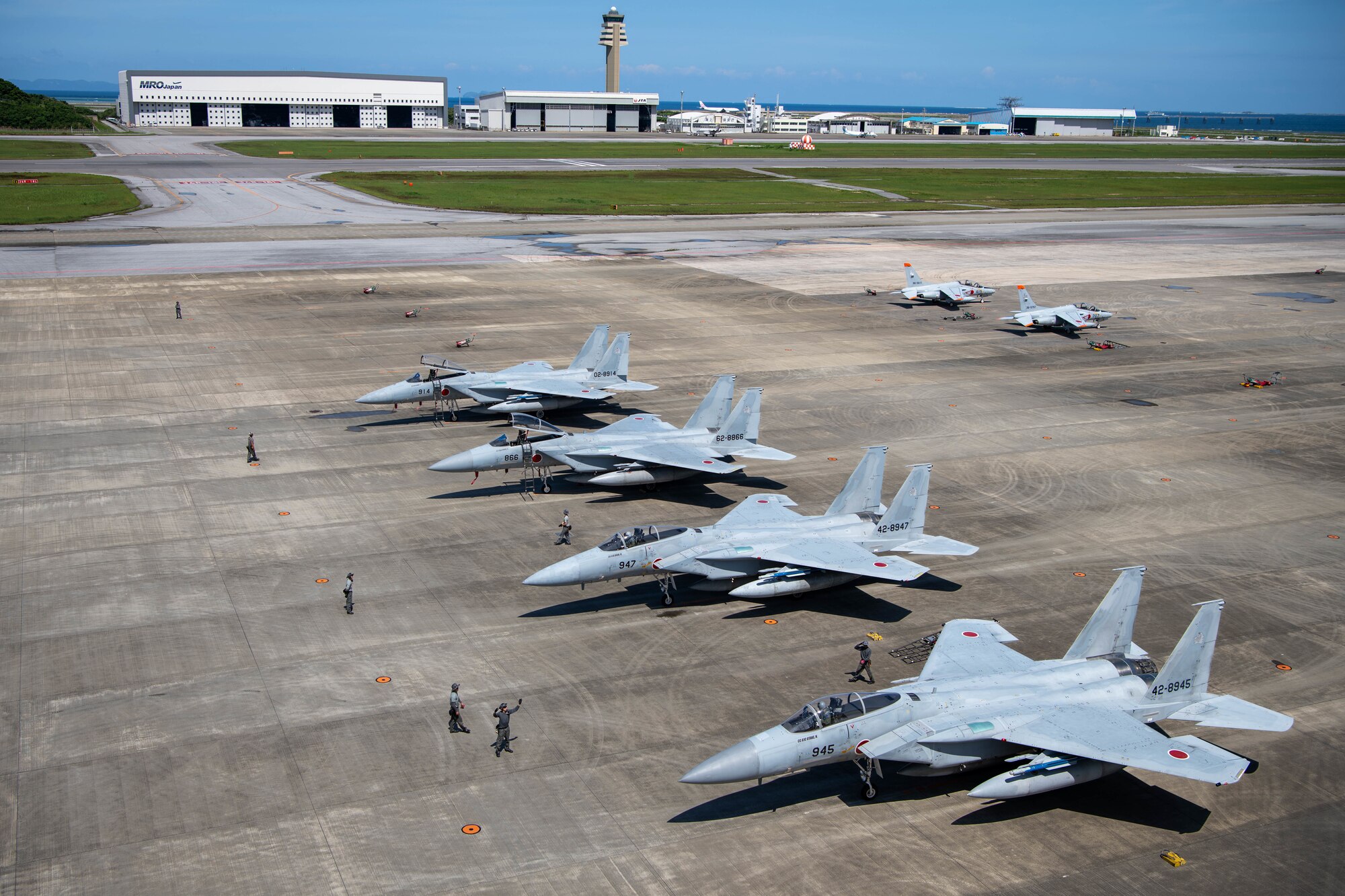 JASDF F-15J Eagles and Kawasaki T-4s prepare for take off.