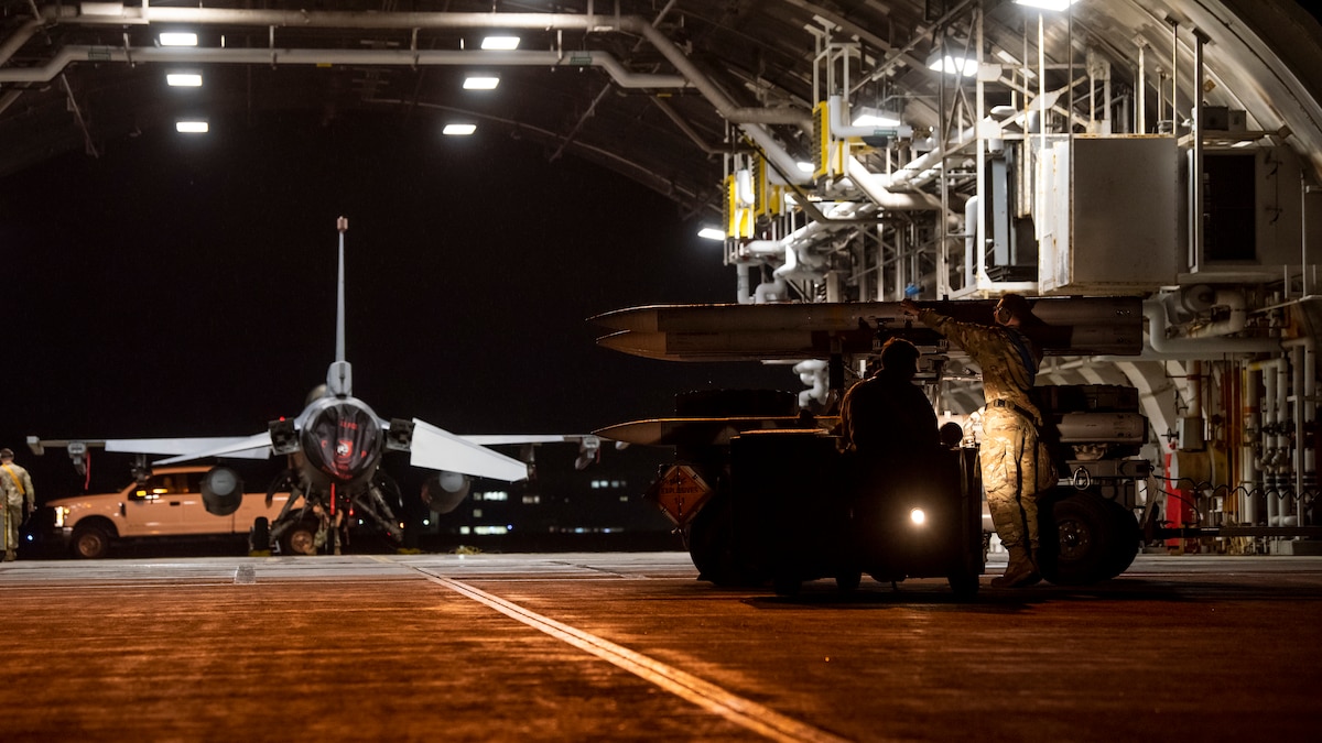 U.S. Air Force 14th Fighter Generation Squadron weapons load crew members secure an AIM-120 advanced medium-range air-to-air missile onto an MJ-1 lift truck during an F-16 Fighting Falcon live weapons load during a Combat Ammunition Production Exercise at Misawa Air Base, Japan, May 6, 2024.