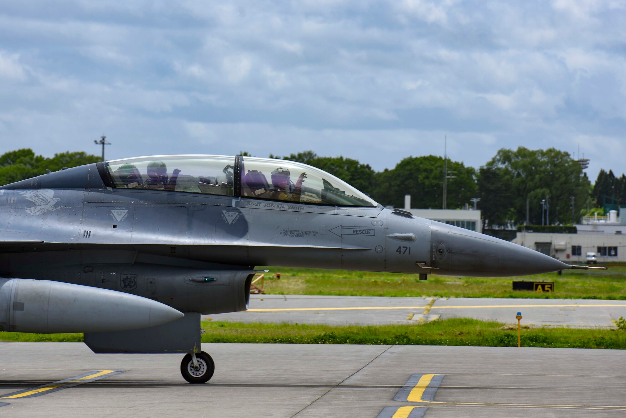 U.S. Air Force Col. Michael Richard, 35th Fighter Wing commander, and Mr. Yoshinori Kohiyama, Misawa City mayor, throw up the claw in tribute to the 13th Fighter Squadron's mascot, the panthers, before a high-speed taxi in an F-16 Fighting Falcon at Misawa Air Base, Japan, May 17, 2024. This gesture symbolized the strong esprit de corps and pride within the squadron. The event was part of the 'Wing Commander for a Day' program, designed to strengthen community relations and give local leaders a firsthand experience of the unit's culture and mission. (U.S. Air Force photo by Staff Sgt. Kristen Heller)