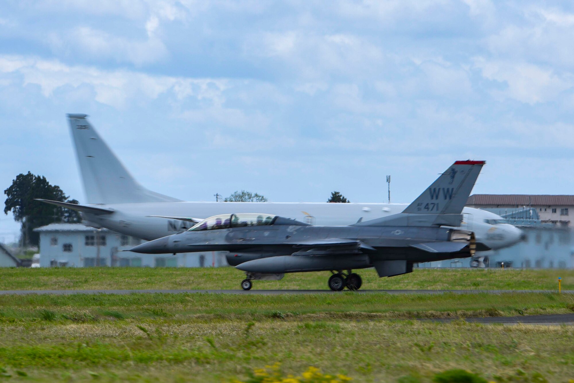 A U.S. Air Force F-16 Fighting Falcon with Col. Michael Richard, 35th Fighter Wing commander, and Mr. Yoshinori Kohiyama, Misawa City mayor on board, taxis parallel to a U.S. Navy P-8 Poseidon at Misawa Air Base, Japan, May 17, 2024. This coincidental moment highlighted the diverse array of aircraft operating at Misawa. Although the P-8 Poseidon was not part of the 'Wing Commander for a Day' program, its presence showcases the collaborative environment and joint capabilities that are integral to the base's mission. (U.S. Air Force photo by Staff Sgt. Kristen Heller)