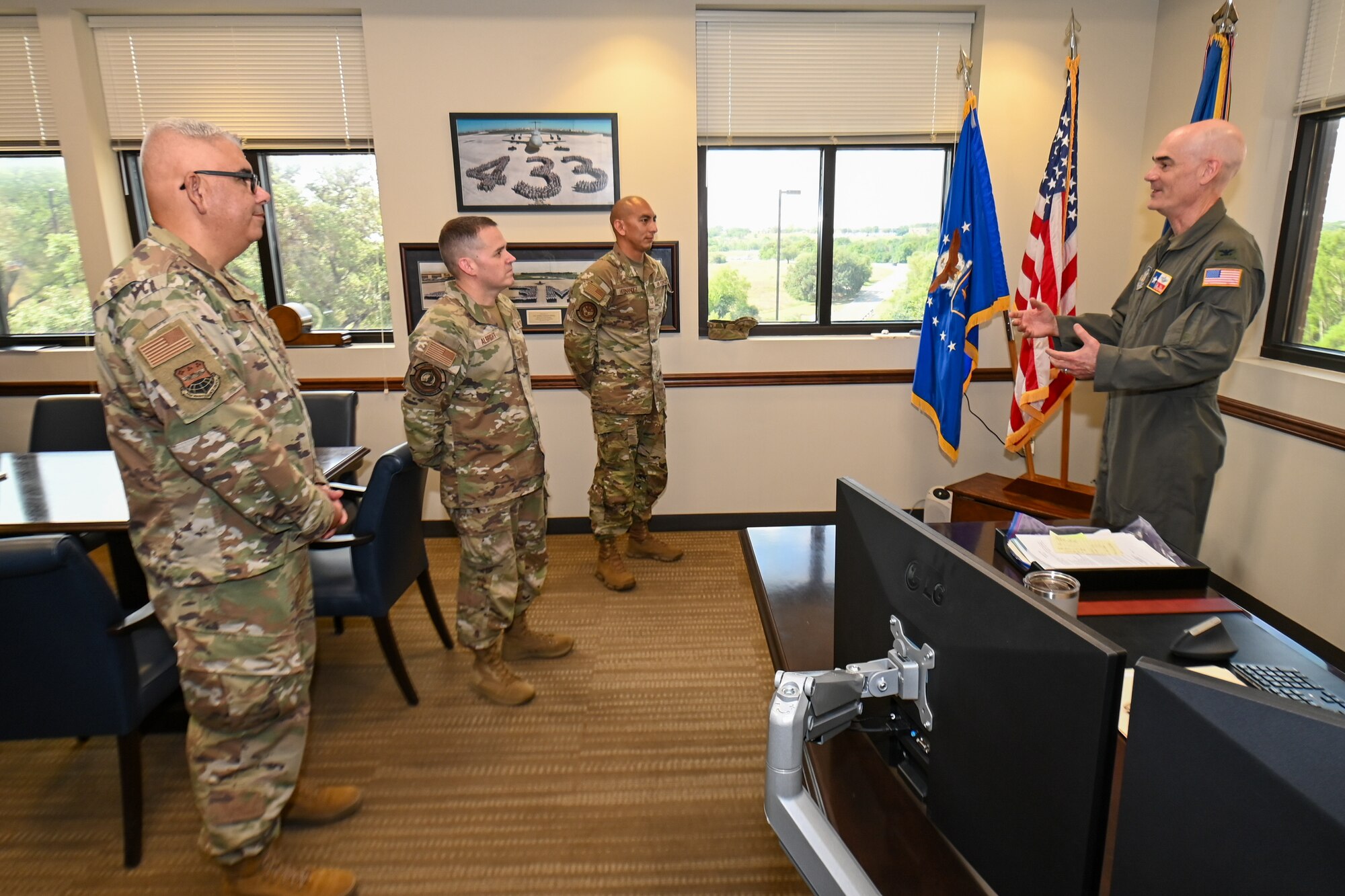 Col. William Gutermuth, right, 433rd Airlift Wing commander, congratulates Senior Master Sgt. Ernesto Compean, left, Chief Master Sgt. Kurtis Albright, center left, and Senior Airman Joe Hernandez, center right, for helping two people hurt in a crash.