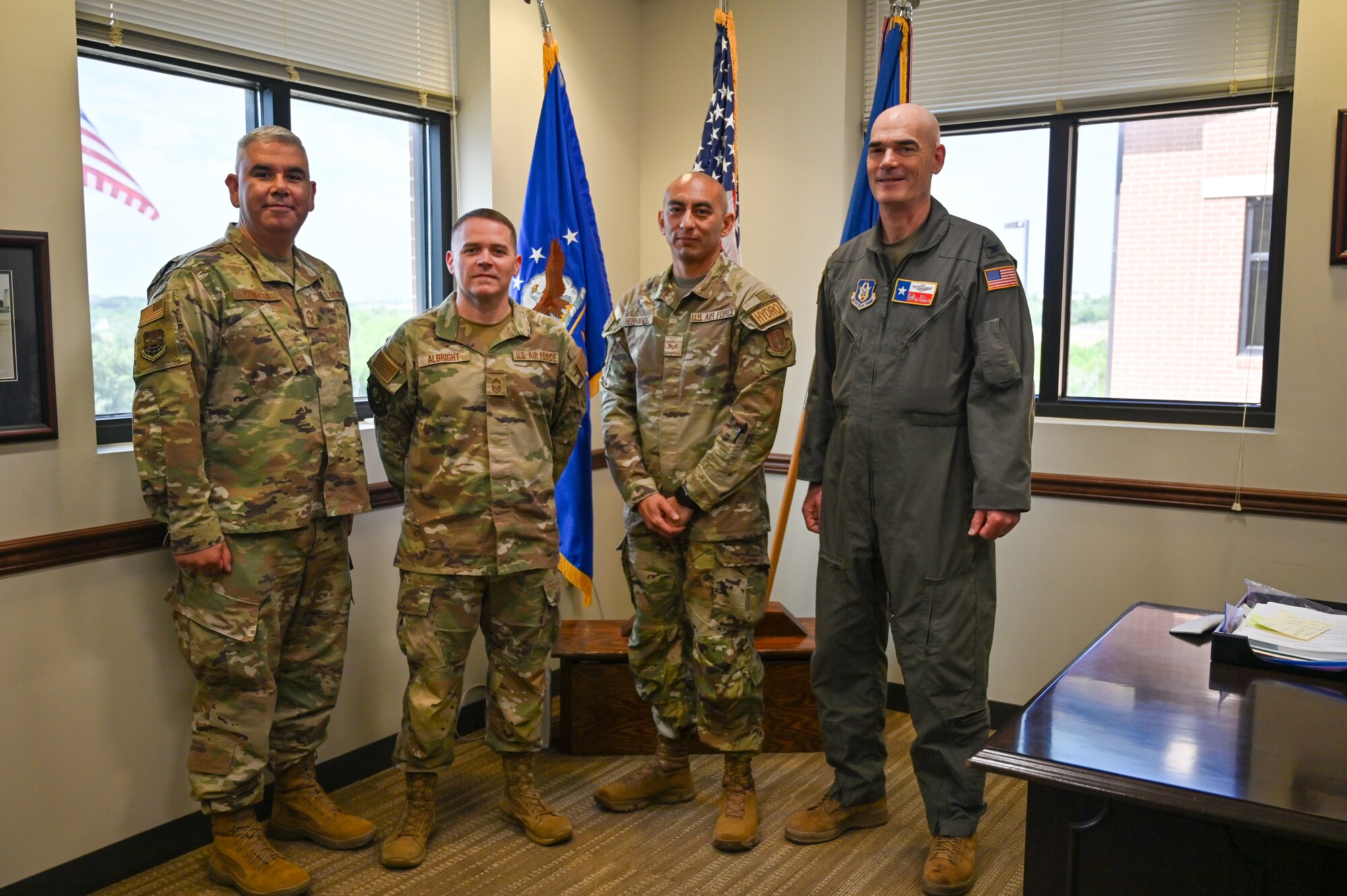Col. William Gutermuth, right, 433rd Airlift Wing commander, Chief Master Sgt. Kurtis Albright, center left, Senior Master Sgt. Ernesto Compean, left, and Senior Airman Joe Hernandez, center right, pose for a group photo after receiving the wing commander’s coin for helping two people hurt in a crash.