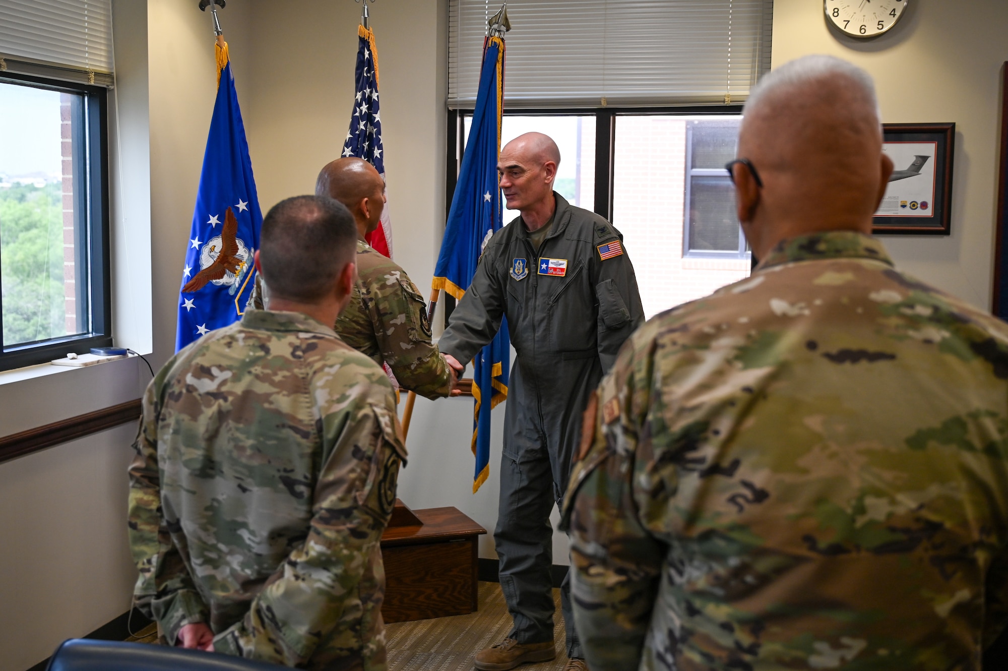 Senior Airman Joe Hernandez, center left, accepts the wing commander’s coin from Col. William Gutermuth, center right, 433rd Airlift Wing commander, for delivering first aid to two people hurt in a crash.