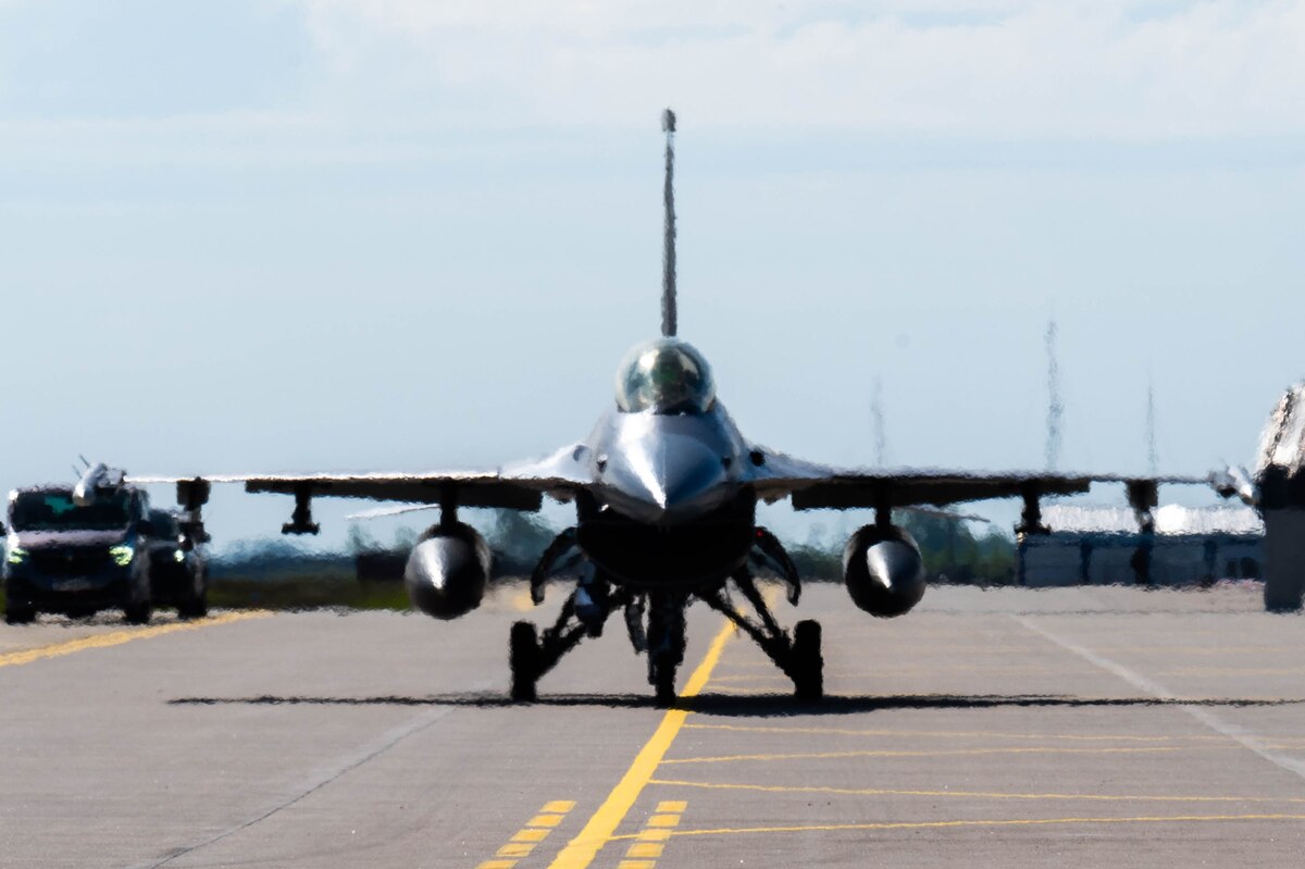 An F-16 taxis down a runway.