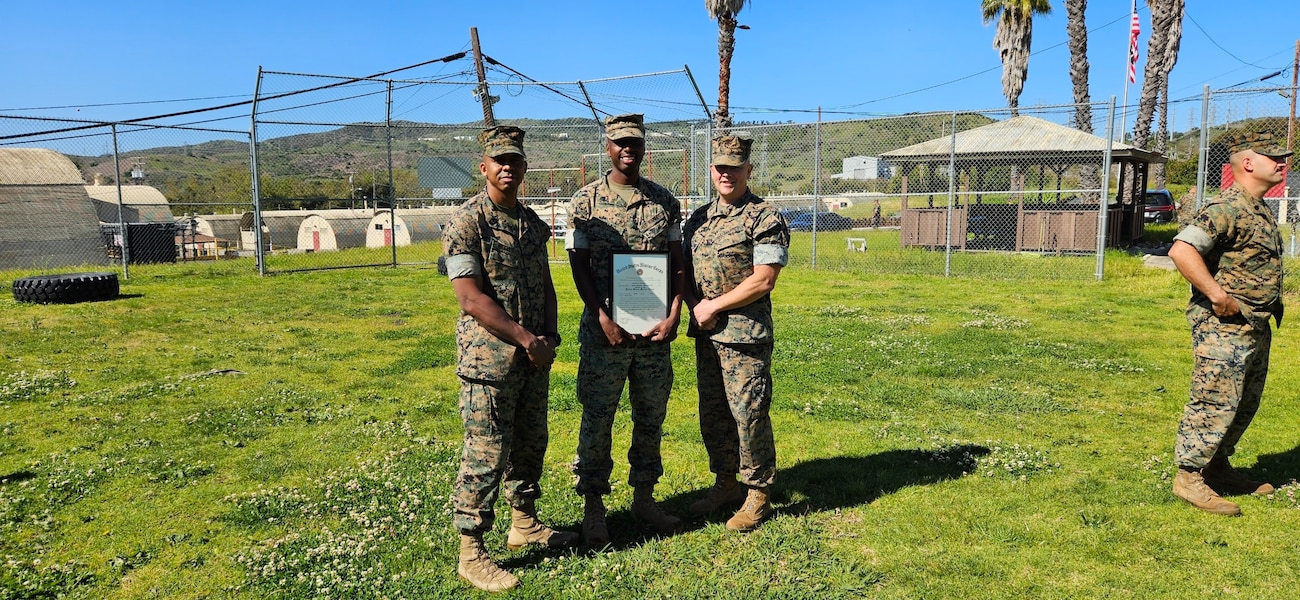 Staff Sergeant Collins along  side of the Commanding Officer and 1stSgt celebrating his Meritorious Promotion.