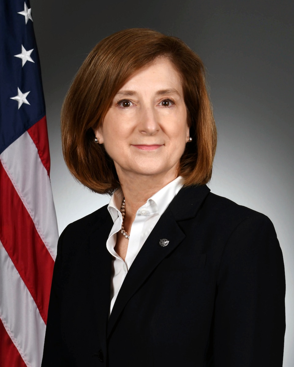 Official photo of a woman with the U.S. flag in the background