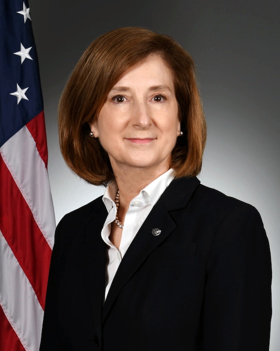 Official photo of a woman with the U.S. flag in the background