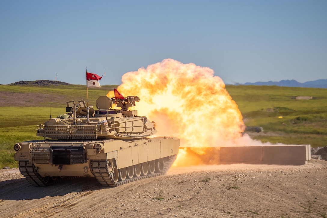 Bright orange flames emit from an Army tank during outdoor training.