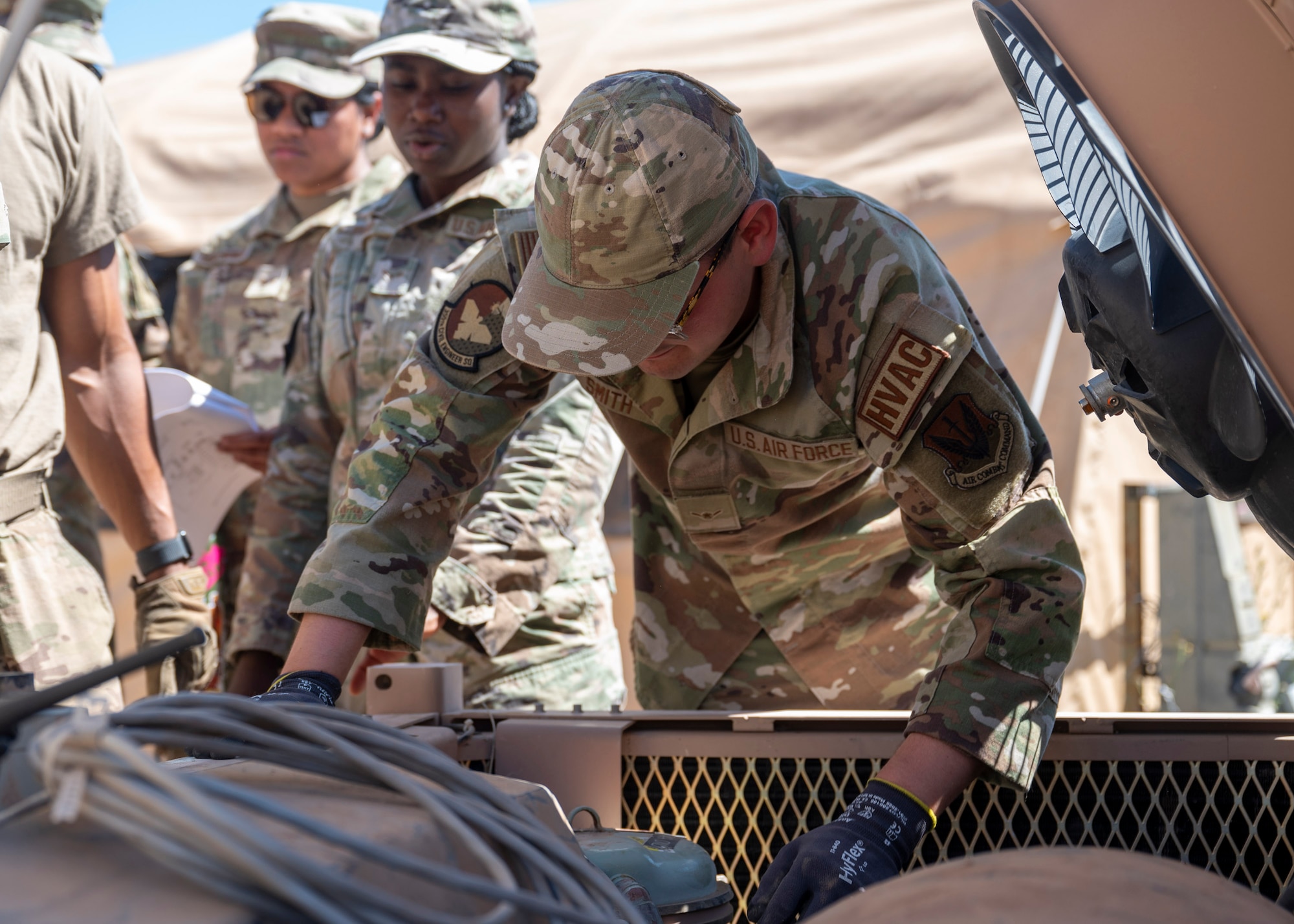 A U.S. Airman assigned to the 355th Civil Engineering Squadron works on an air conditioning unit during the Mission Support Group Phase II training exercise at Davis-Monthan Air Force Base, Ariz., May 13, 2024. The Phase II exercise focused on operations in a degraded environment and base recovery after an attack. (U.S. Air Force photo by Airman 1st Class William Finn V)