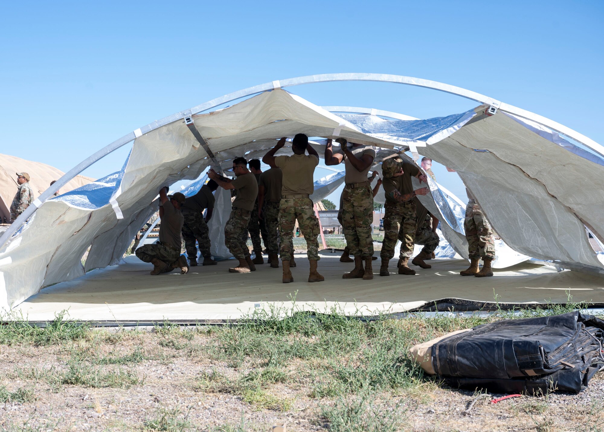 U.S. Airmen build a tent during the Mission Support Group Phase II training exercise at Davis-Monthan Air Force Base, Ariz., May 14, 2024. The Phase II exercise focused on operations in a degraded environment and base recovery after an attack. (U.S. Air Force photo by Airman 1st Class William Finn V)