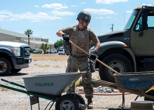 A U.S. Airman from the 355th Civil Engineering Squadron mixes concrete during the Mission Support Group Phase II training exercise at Davis-Monthan Air Force Base, Ariz., May 14, 2024. The concrete was used to fill holes caused by a simulated attack to the flightline. (U.S. Air Force photo by Airman 1st Class William Finn V)