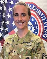 Female Soldier posed in front of U.S. flag and USAREC flag.