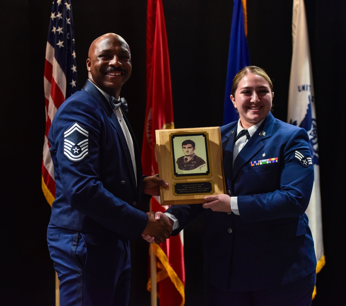 U.S. Air Force Senior Airman Aundrea Valle, 47th Operation Medical Readiness Squadron, is presented the John L. Levitow Award by Senior Master Sgt. Eric Adams, 47th Security Forces Squadron operational superintendent. Airman Leadership School is a five-week course designed to prepare senior airmen to assume supervisory duties through instruction in leadership, followership, and written and oral communication skills. (U.S. Marine Corps photo by Corporal Jessica Roeder)