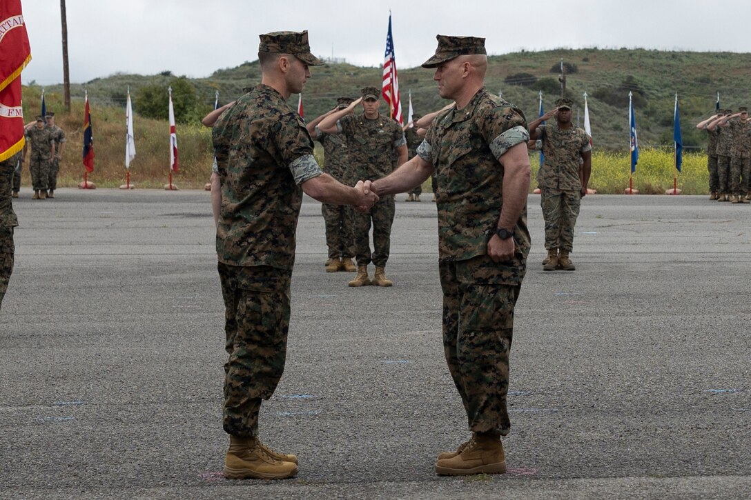 U.S. Marine Corps Lt. Col. Robert D. Reagles, left, incoming commanding officer of 1st Intelligence Battalion, I Marine Expeditionary Force Information Group, shakes hands with Lt. Col. Jason P. Pellerin, the outgoing commanding officer of 1st Intelligence Battalion, during the 1st Intelligence Battalion change of command ceremony at Marine Corps Base Camp Pendleton, California, May 17, 2024. The change of command ceremony commemorated the passing of command from Pellerin to Reagles. (U.S. Marine Corps photo by Lance Cpl. Nicole Stuart)