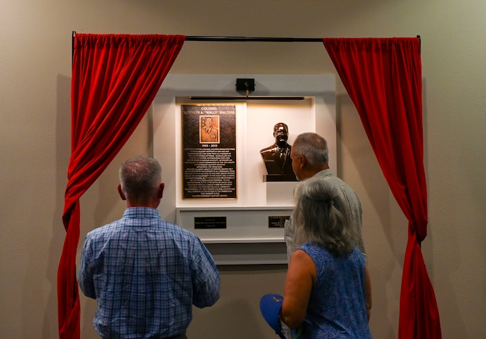People look at a bust and legacy plaque