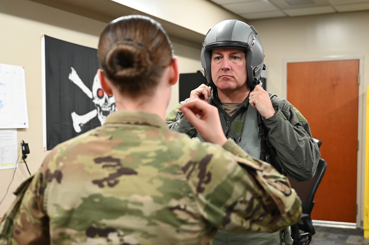 U.S. Air Force Airman Sierra Muchler, 85th Test and Evaluation Squadron, aircrew flight equipment journeyman, assists Chief Master Sgt. David Wolfe, command chief of Air Combat Command, as he adjusts his helmet in preparation for his F-15EX Eagle II familiarization flight at Eglin Air Force Base, Florida, April 11, 2024. During his flight, Wolfe witnessed the capabilities of the F-15EX first-hand in a tactically relevant environment. (U.S. Air Force photo by Capt. Lindsey Brewer)