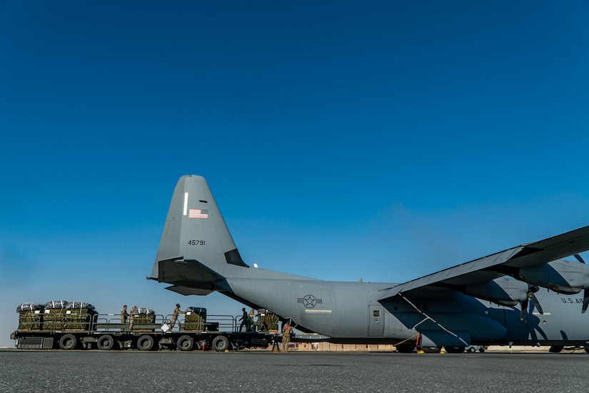 Airmen load pallets of food and water destined for airdrop over Gaza aboard a C-130J Super Hercules
