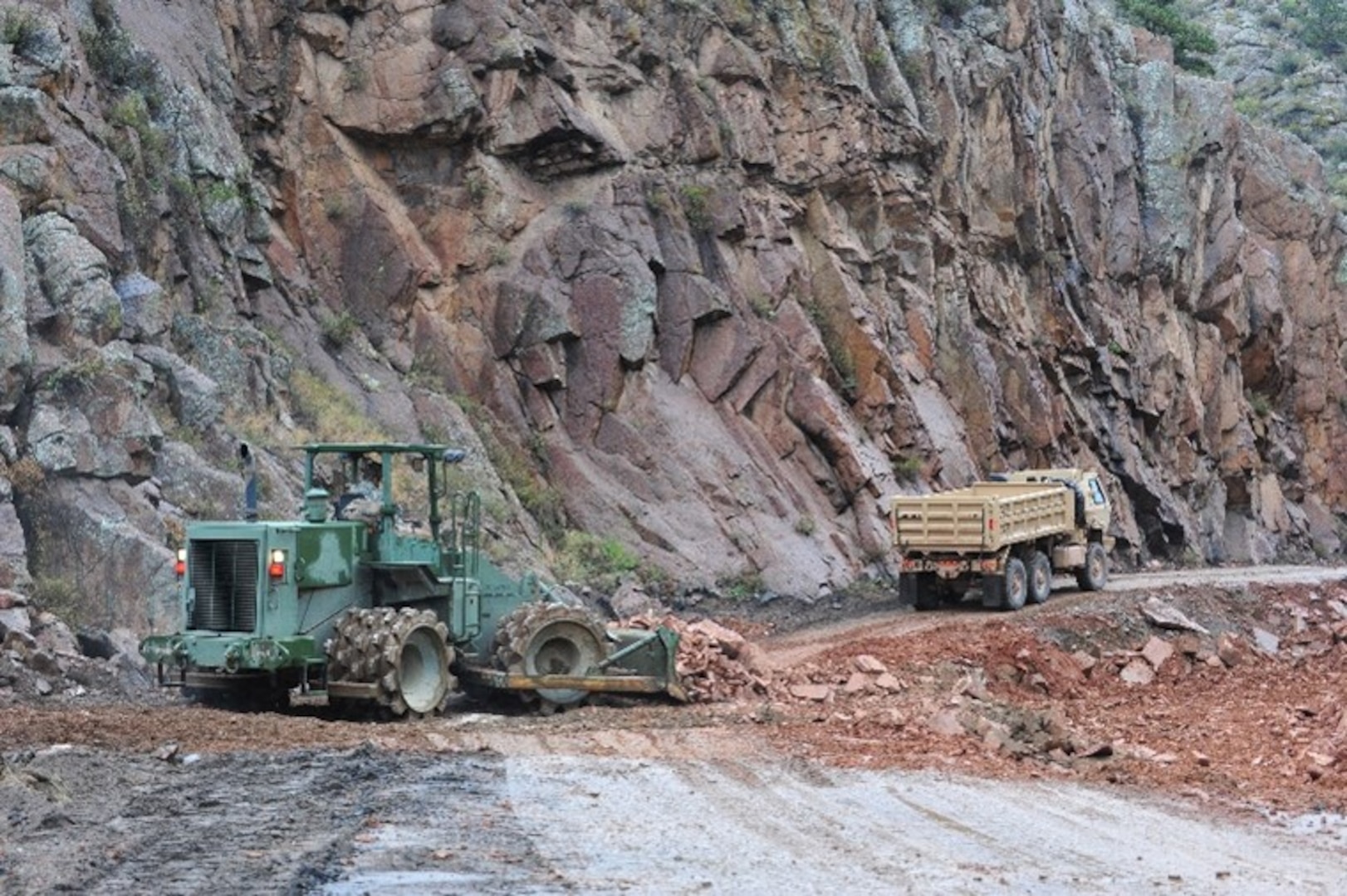 Colorado National Guard engineers operating a bulldozer and dump truck while rebuilding highway 36 in 2013