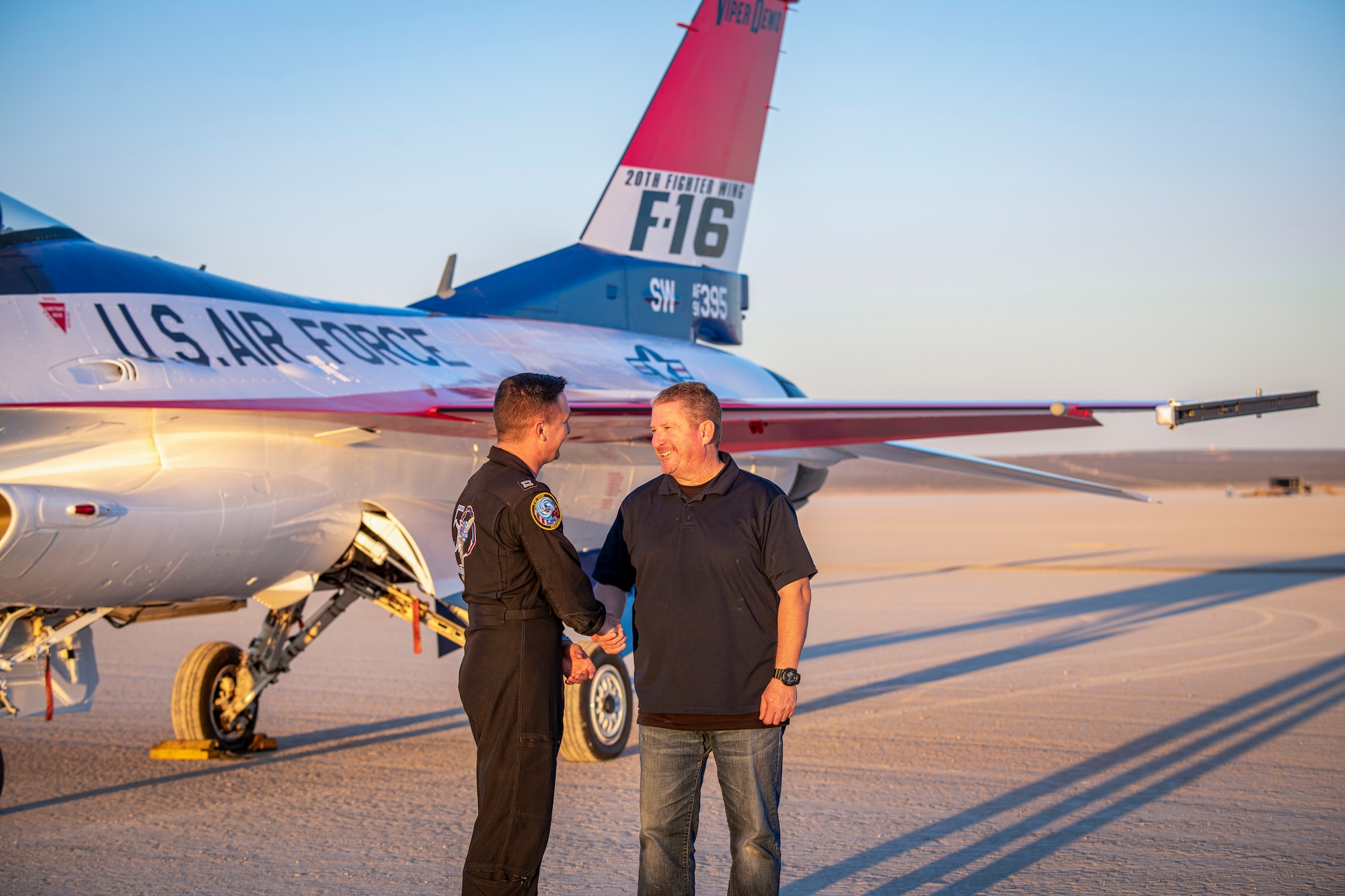 Capt. Taylor Hiester, F-16 Viper Demonstration Team commander and pilot thanks Tony Accurso, 416th Flight Test Squadron logistics manager, for his work in managing the repainting project on the F-16 demonstration aircraft. The 412th Maintenance Group, Fabrication Flight - Corrosion Control Team recently repainted the F-16 Viper Demo Team aircraft in the classic YF-16 livery to commemorate the platform's first flight 50 years ago at Edwards Air Force Base, California. (Air Force photo by Giancarlo Casem)