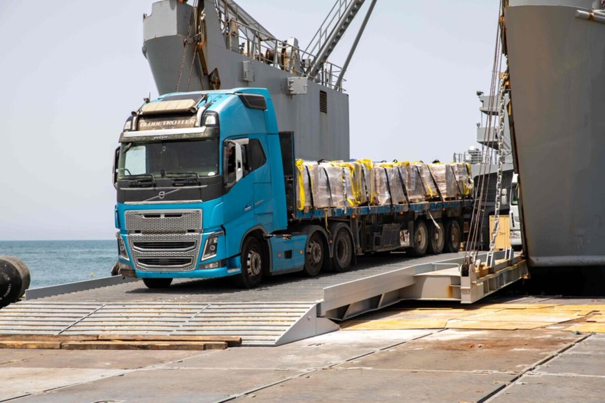 A truck carrying cargo of aid supplies rolls off a causeway.