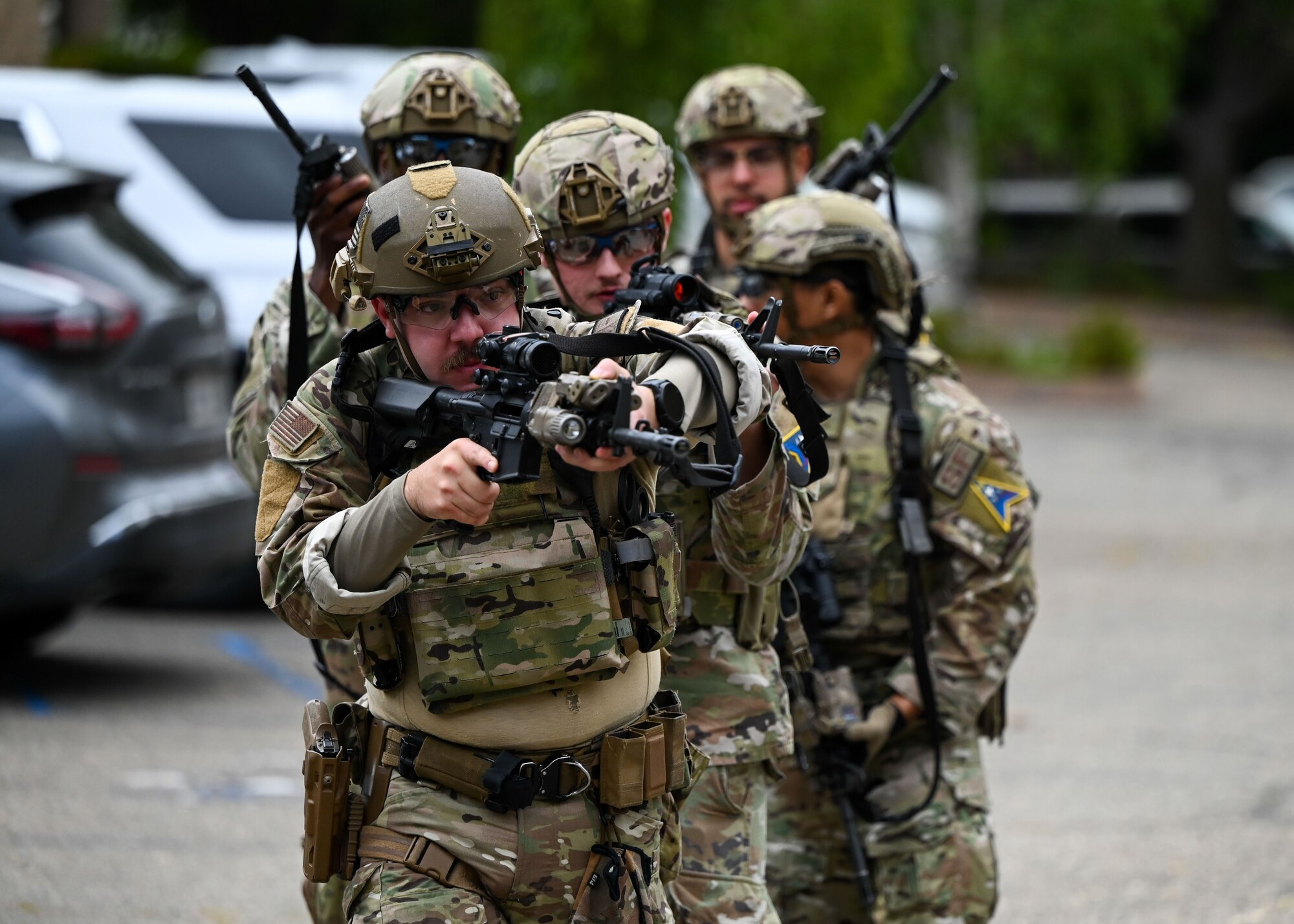 A group of defenders with their weapons out walk together as a team.