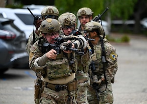 A group of defenders with their weapons out walk together as a team.