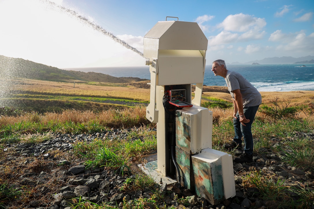 Charles Ronie, a contractor working with Marine Corps Base Hawaii’s Environmental Compliance and Protection Division, inspects a fire-prevention water cannon, MCBH, April 3, 2024. The water cannons, on MCBH’s Crater Range, are a series of remote-controlled devices designed to protect the Ulupa’u Head Wildlife Management Area from potential spot fires. (U.S. Marine Corps photo by Lance Cpl. Carlos Daniel Chavez-Flores)