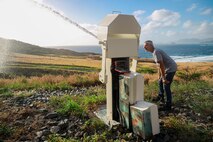 Charles Ronie, a contractor working with Marine Corps Base Hawaii’s Environmental Compliance and Protection Division, inspects a fire-prevention water cannon, MCBH, April 3, 2024. The water cannons, on MCBH’s Crater Range, are a series of remote-controlled devices designed to protect the Ulupa’u Head Wildlife Management Area from potential spot fires. (U.S. Marine Corps photo by Lance Cpl. Carlos Daniel Chavez-Flores)