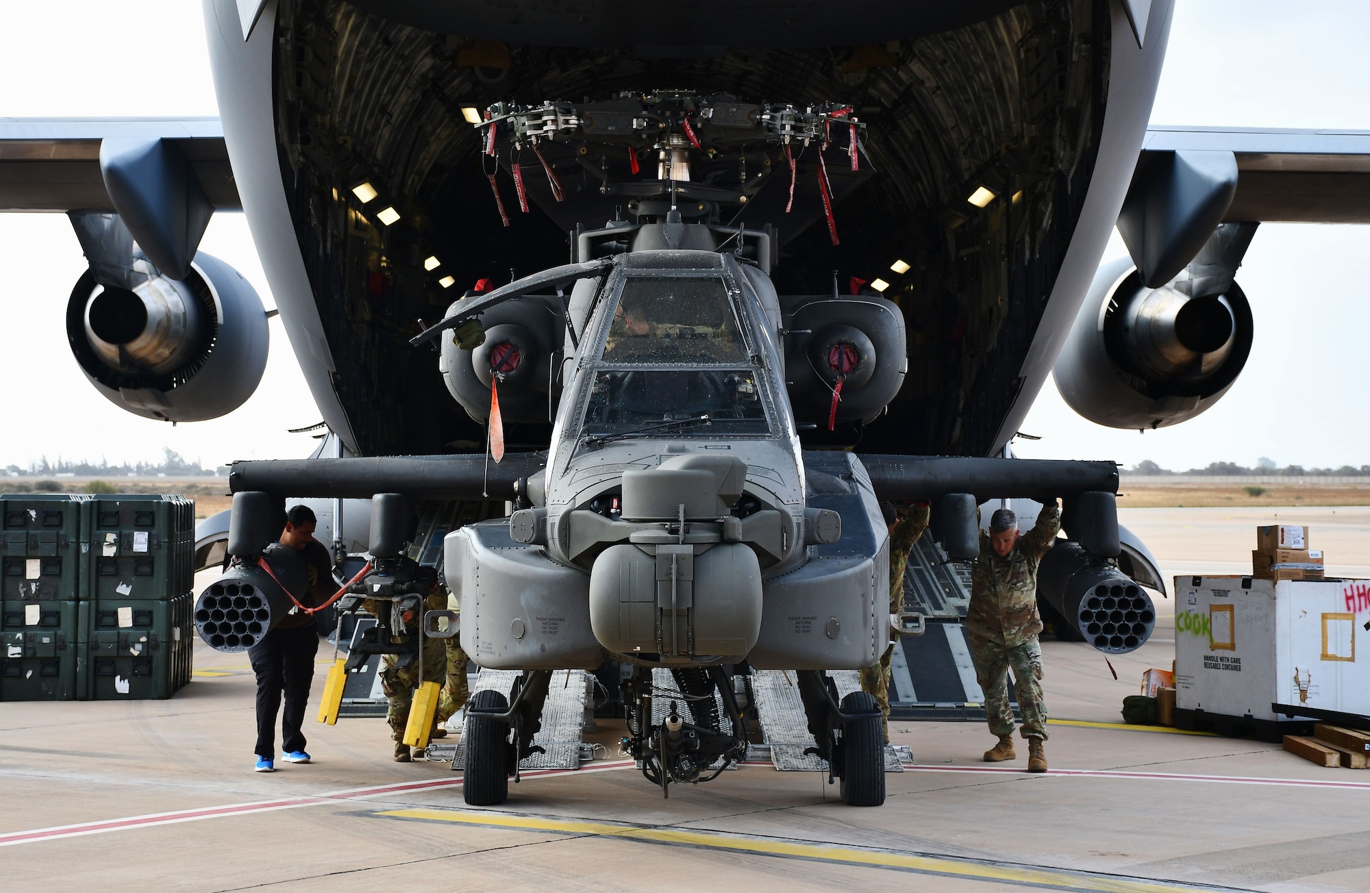 Soldiers from 1st Battalion, 211th Aviation Regiment, Utah National Guard, help guide an AH-64 Apache attack helicopter off a C-17 Globemaster III, Agadir-Al Massara International Airport, Agadir, Morocco, May 17, 2024, in preparation for African Lion 2024. This year marks the 20th anniversary of U.S. Africa Command’s premier joint exercise led by U.S. Army Southern European Task Force, Africa (SETAF-AF), running from April 19 to May 31 across Ghana, Morocco, Senegal and Tunisia, with over 8,100 participants from 27 nations and NATO contingents. (U.S. Army photo by Maj. Alun Thomas)