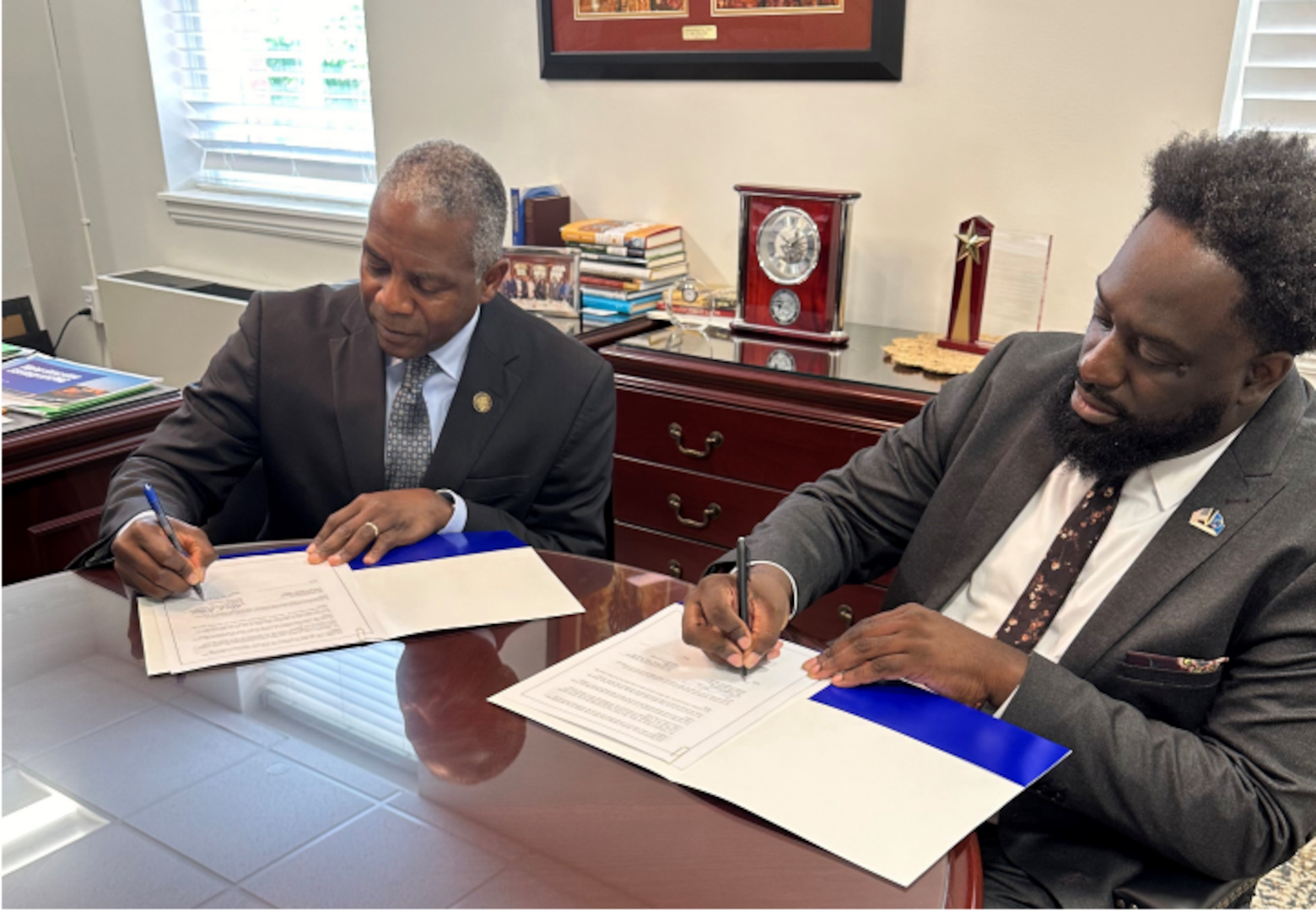 Former Defense Logistics Agency Director Lt. Gen. Darrell K. Williams and DLA’s Chief Information Officer Adarryl Roberts sign a memorandum.