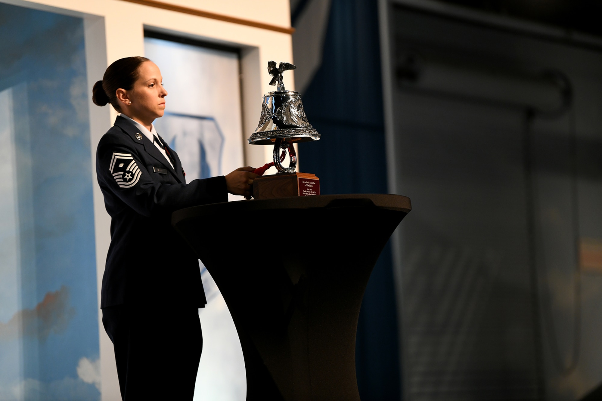 Woman in military uniform stands behind podium