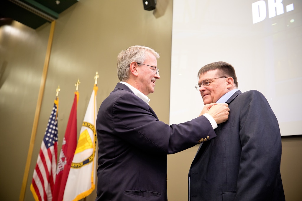 Dr. David Horner receives a pin from Dr. David Pittman at retirement ceremony
