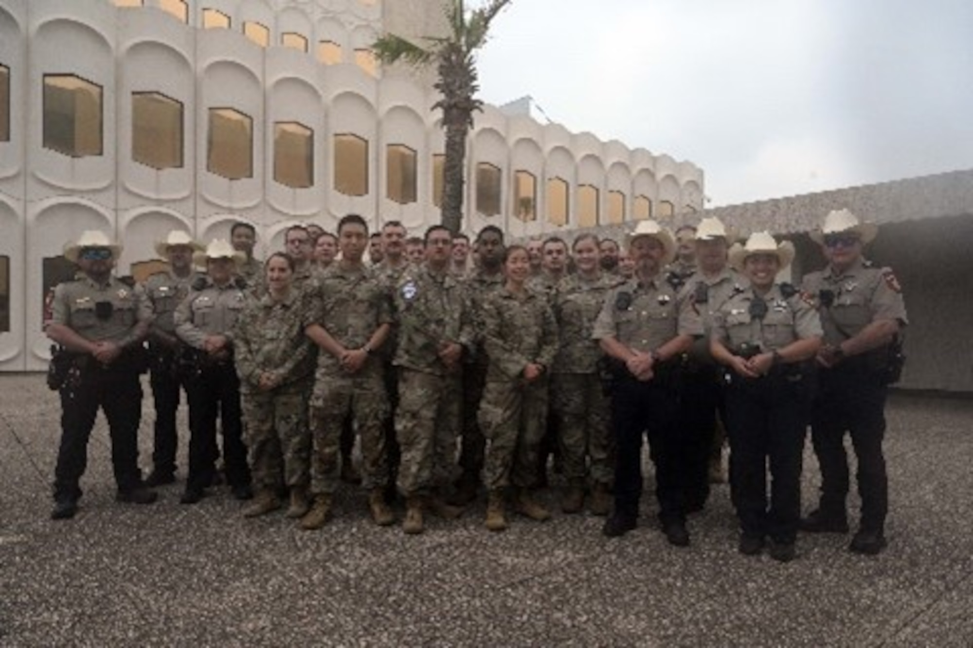 A group of Airmen and police officers posing outside for a photo.