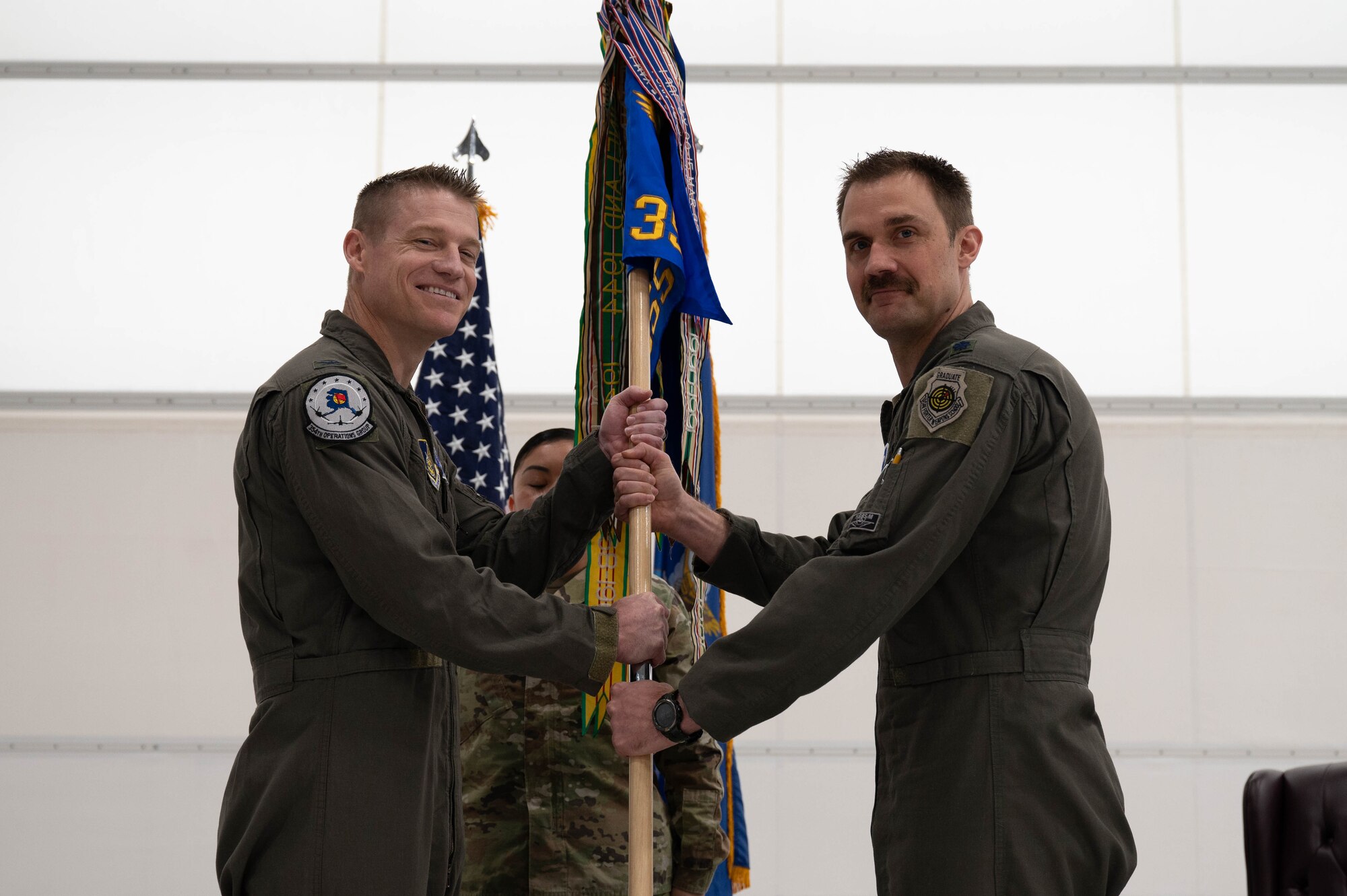 U.S. Air Force Col. Curtis Dougherty (left), 354th Operations Group commander, receives the guidon from Lt. Col Michael Mickus, 355th Fighter Squadron outgoing commander, during a change of command ceremony at Eielson Air Force Base, Alaska, May 17, 2024.